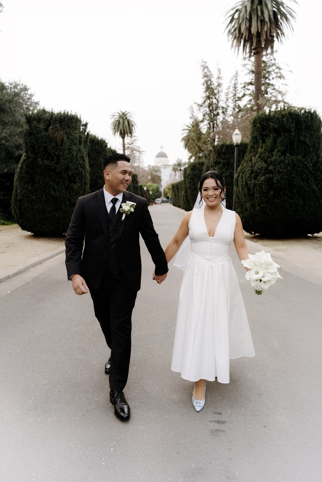 Newlyweds walking hand in hand near the Capitol