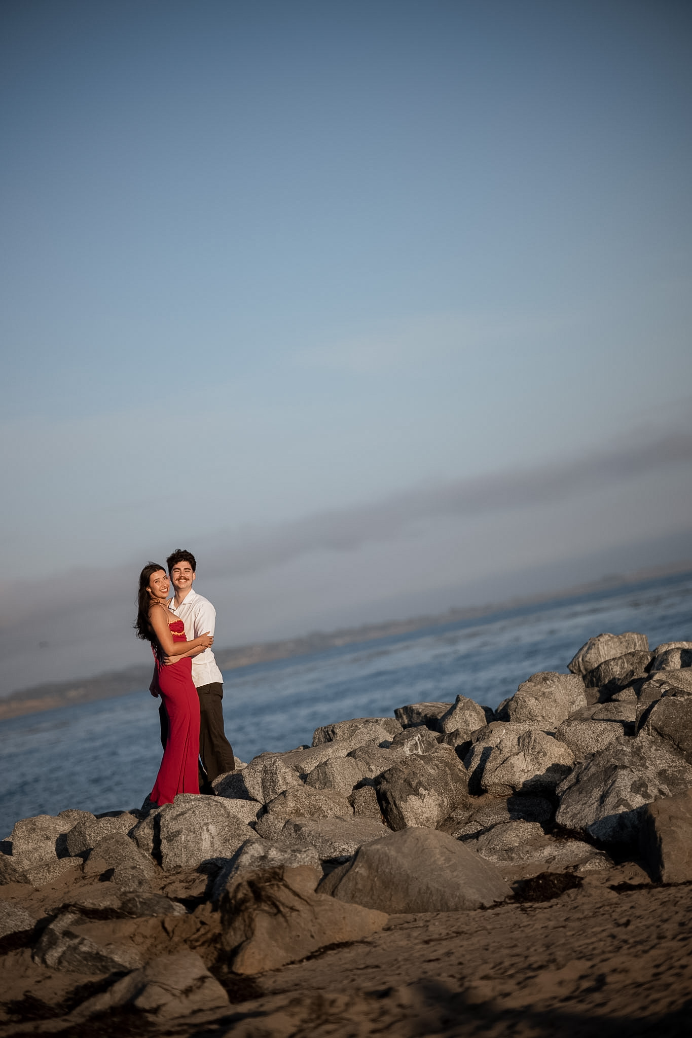 Engaged couple embracing on the coast